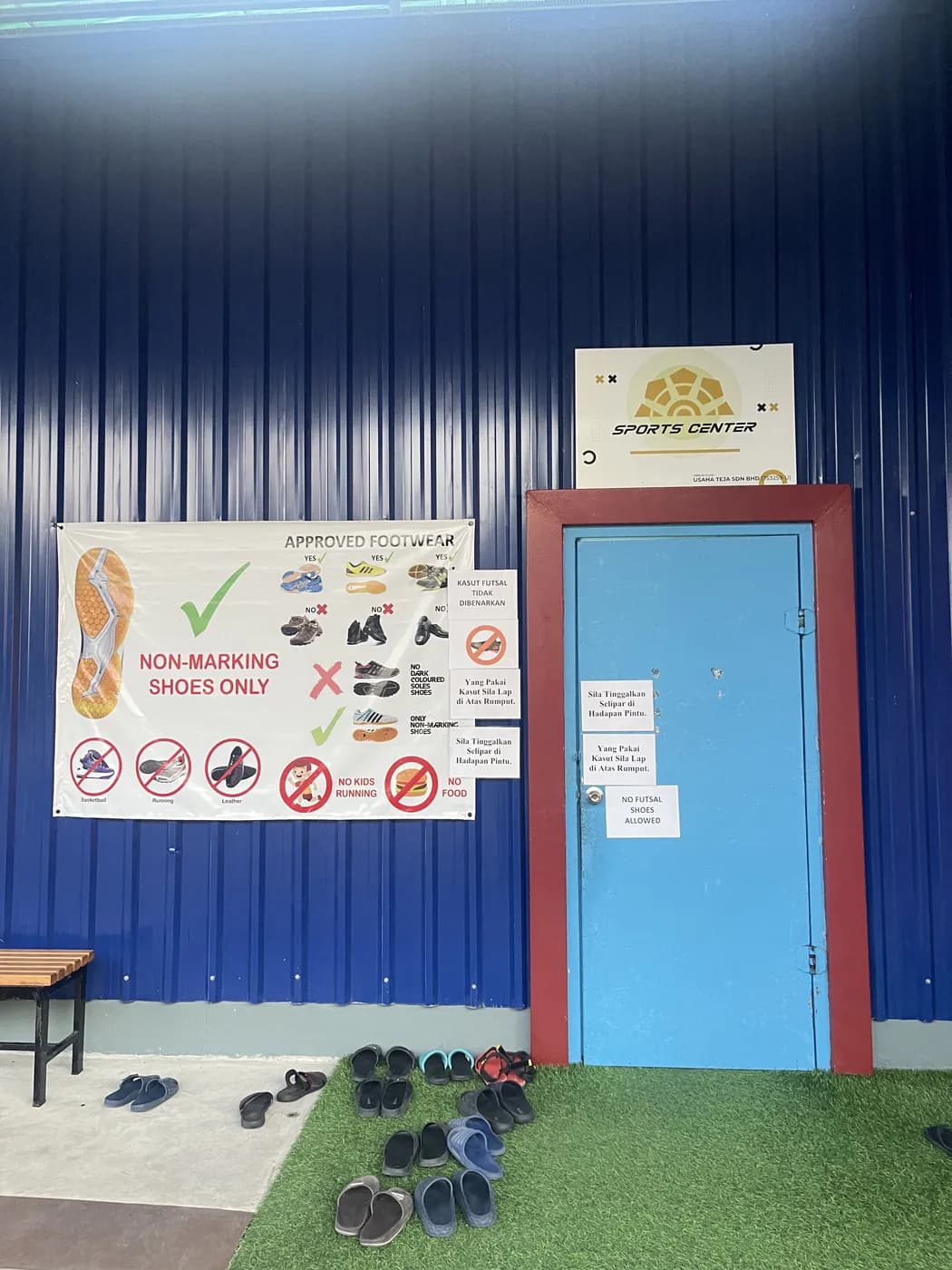 Outdoor footwear left outside the court door, beside the notice board